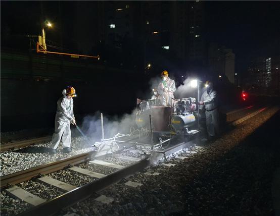한국철도 직원들이 야간에 레일온도 상승을 억제하는 열차단 페인트를 선로에 도포하고 있다. [제공=한국철도]