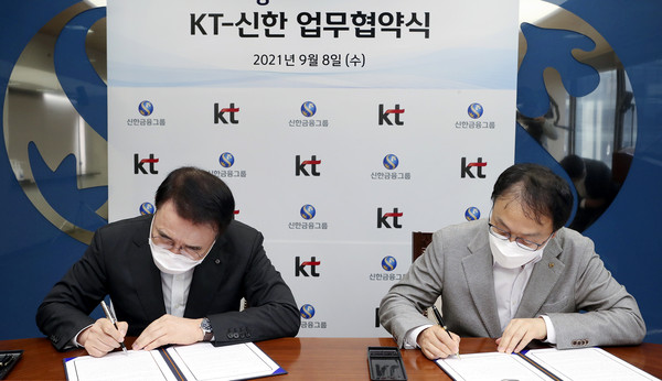 구현모 KT 대표(오른쪽)와 조용병 신한금융그룹 회장이 업무협약서에 서명을 하고 있다 [사진=KT]